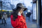 Woman In Red Coat With Smartphone In Hands Going Through The Cit Stock Photo