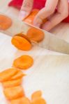 Woman Hand Cutting Carrots In Kitchen Stock Photo