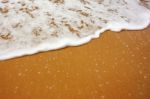 Sea Wave With Foam On Sand Stock Photo