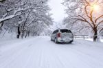 Car And Falling Snow In Winter On Forest Road With Much Snow Stock Photo