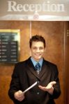 Male Receptionist Holding Paper Stock Photo