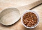 Uncooked Brown Rice In A Cup With Wooden Ladle Stock Photo