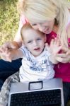 Caring Mother With Laptop And Her Child Stock Photo