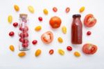 Tomatoes Juice In Bottle And Fresh Tomatoes On White Wooden Back Stock Photo