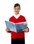 Smiling Schoolgirl Reading Book Stock Photo