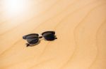 Black Sunglasses On Summer Desert Sand Dunes  On The Sand Stock Photo