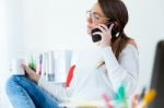 Pretty Young Woman Using Her Mobile Phone In The Office Stock Photo