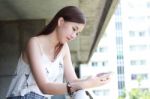 Portrait Of Thai Adult Beautiful Girl Using Her Smart Phone And Smile Stock Photo