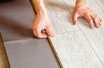 Handyman's Hands Laying Down Laminate Flooring Boards Stock Photo