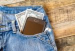 Dollar Money And Smart Phone In Pocket Blue Jeans Stock Photo