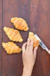 Hand Cutting Croissant Stock Photo