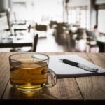 Hot Tea With Notebook And Pen On Wooden Table Stock Photo