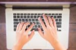 Typing On Keyboard Laptop Top View Of Wooden Table Stock Photo