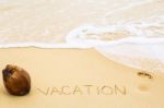 Inscription Of Word Vacation Written On Wet Yellow Beach Sand, F Stock Photo