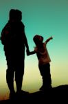 Silhouette Back View Of Mother And Daughter Clasping Hand Togeth Stock Photo