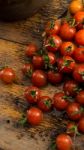 Cherry Tomatoes On Display On Wooden Chopping Board And Wooden Table Stock Photo