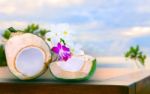 Twon Half Of Green Coconut Water On Top  Wood Table With Tropical Orchid Flowers And White  Frangipani Bouquet Decorated Stock Photo