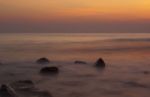 Soft Waves On A Rocky Beach In The Evening Stock Photo