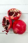 Fresh Pomegranate Fruits Isolated On A White Wooden Background Stock Photo