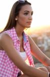 Pretty Girl Sitting On The Roof At Sunset Stock Photo