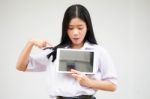 Portrait Of Thai High School Student Uniform Beautiful Girl Using Her Tablet Stock Photo