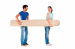 Young Couple Carrying A Carpet Stock Photo