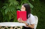 Thai Adult Student University Beautiful Girl Reading Red Book Stock Photo