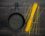 The Thin Spaghetti On Black Wooden Background. Yellow Italian Pa Stock Photo