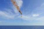 Crane Boom And Crane Hook In The Sea With Sky And Clouds Backgro Stock Photo