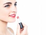 Cheerful Teen Girl Applying Red Lipstick Stock Photo