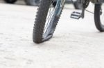 Bicycle Wheel With Flat Tyre On The Concrete Road Stock Photo