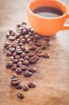 Coffee Beans With Coffee Cup On Wooden Table Stock Photo