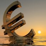 Euro Sinking In Sea At Sunset Stock Photo