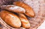 Rye And Wheat Bread Loafs In A Rustic Braided Basket Stock Photo