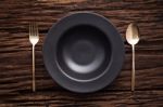 Black Bowl Plate Fork Spoon On Wooden Table Background Stock Photo