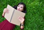 Woman Lying On Green Grass With  Book Stock Photo