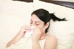 Woman With Cold Sneezing Into Tissue Stock Photo