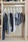 Clothes Hanging In Wooden Wardrobe Stock Photo