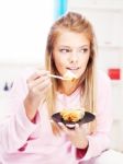 Woman Eating Cake At Home Stock Photo