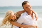 Couple Piggyback Ride At Beach Stock Photo