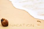 Inscription Of Word Vacation Written On Wet Yellow Beach Sand, F Stock Photo