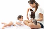 Mother Is Playing A Guitar For Her Baby Stock Photo