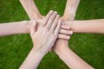 Arms Uniting Above Grass Stock Photo