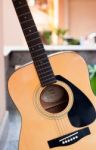 Acoustic Guitar On Orange Wall Background Stock Photo