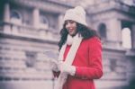 Beautiful Woman In Red Coat And Wool Cap And Gloves With Smartph Stock Photo