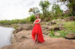 Beautiful Woman Wear Red Evening Dress Over Mountains And Rivers Stock Photo