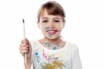 Cheerful Kid Holding A Paint Brush Stock Photo