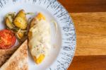 Omelet With Potato, Tomatoes Parsley And Feta Cheese And Bread In White Plate On Wooden Table Stock Photo