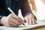 Businessman Writing In A Document. Focus On The Tip Of The Pen Stock Photo