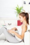 Woman Smiling While Working On Laptop Stock Photo